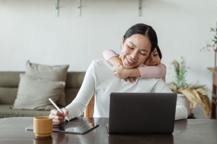 child hugging their parent working